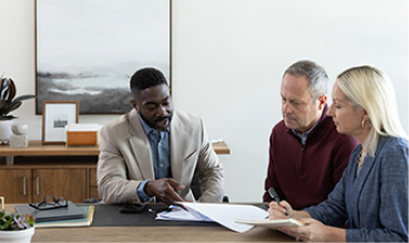 A financial advisor showing paperwork to a man and a woman